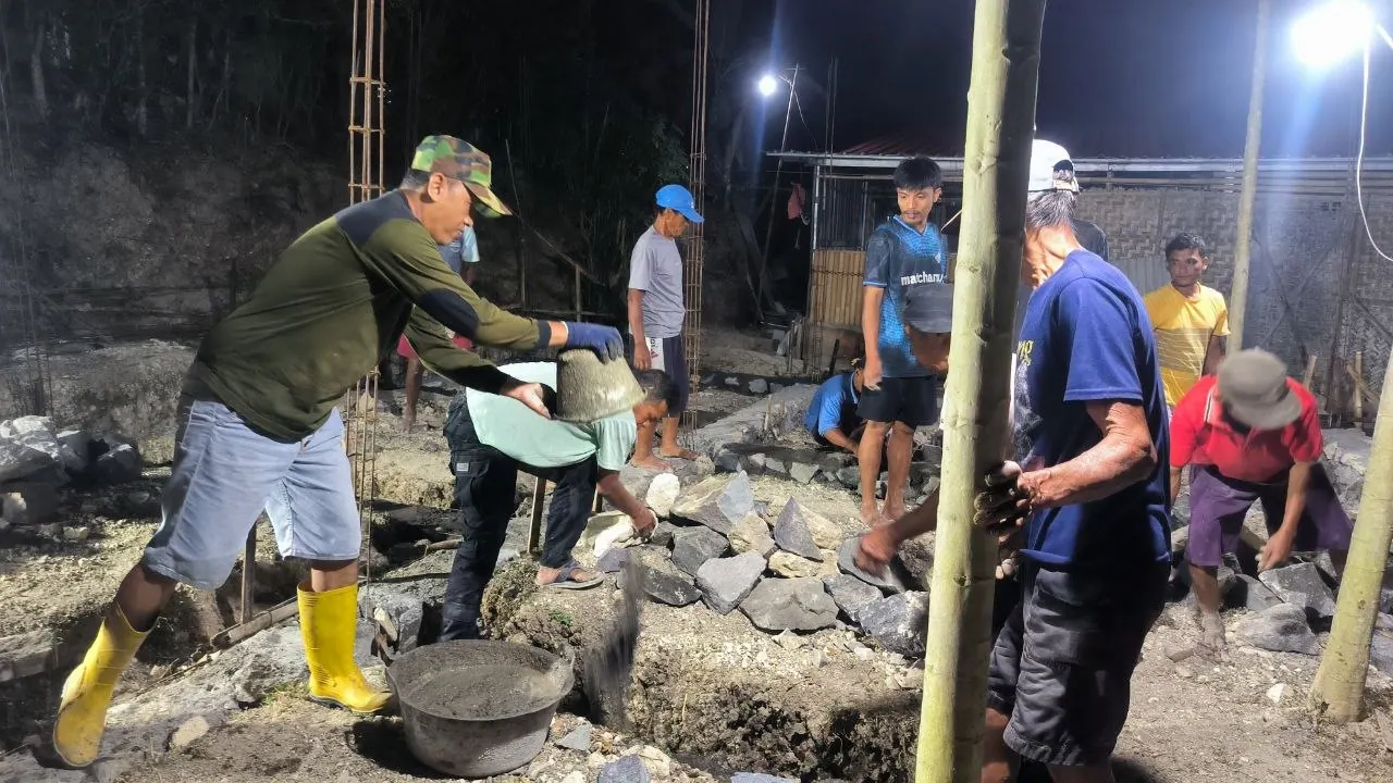 Warga RT 03 Salakan bergotong royong memasang pondasi rumah pada malam hari